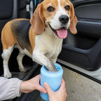 Beagle dont on nettoie la patte boueuse avec le nettoyeur de pattes Copilote avant de monter en voiture